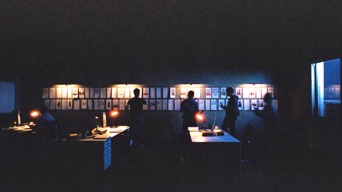 Studio at night: a team at work in front of a wall of boards