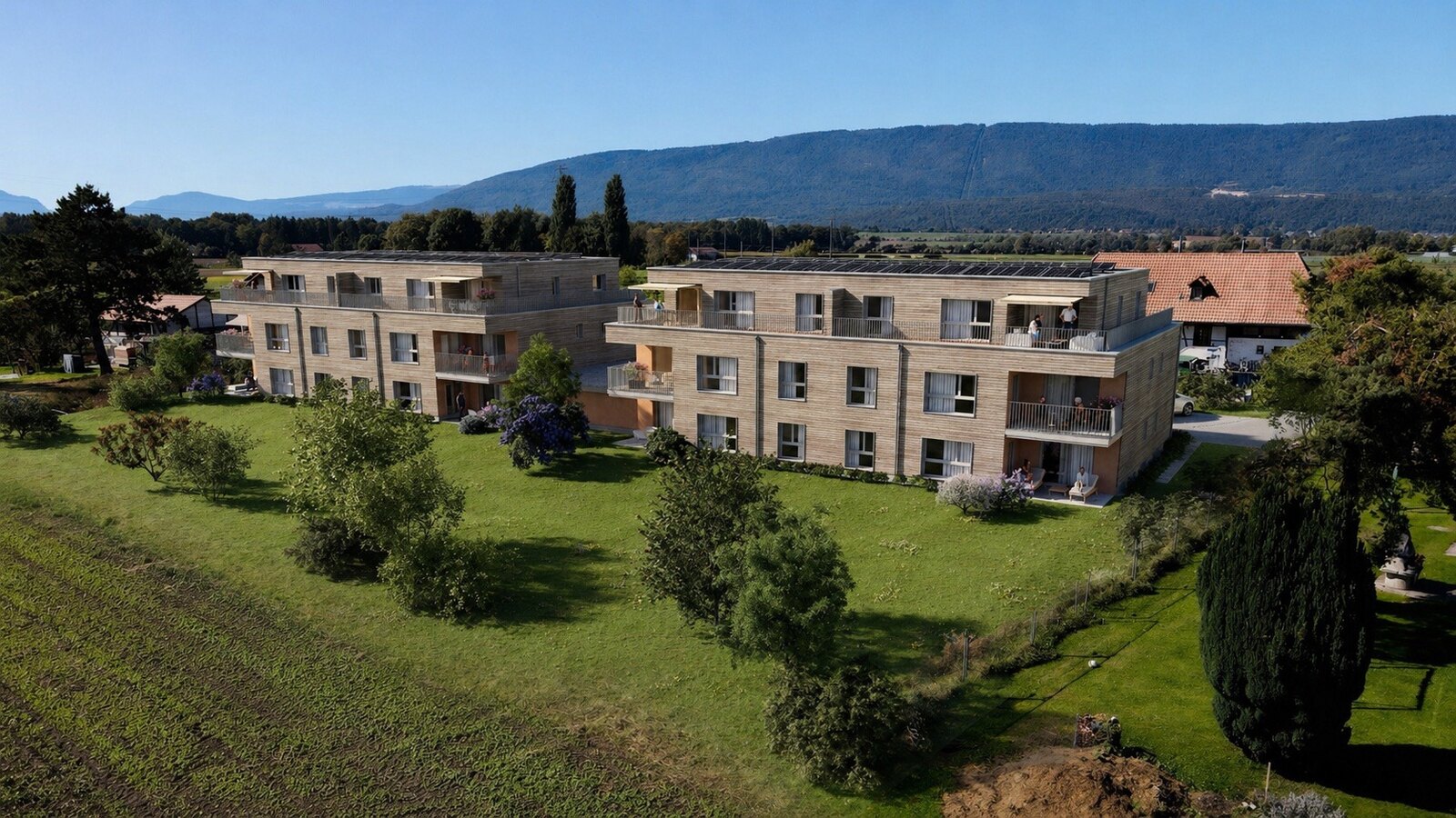 Arboréa, Gampelen : immeuble résidentiel en bois et son jardin